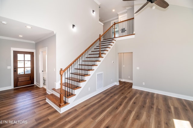 foyer entrance featuring visible vents, crown molding, baseboards, and wood finished floors