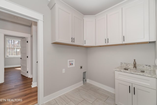 laundry room featuring baseboards, cabinet space, a sink, washer hookup, and electric dryer hookup