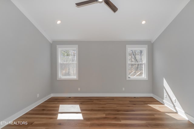 spare room with plenty of natural light, wood finished floors, and crown molding