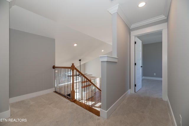 corridor featuring crown molding, an upstairs landing, baseboards, and carpet floors