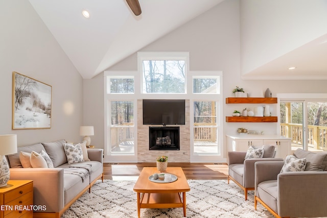 living room featuring recessed lighting, high vaulted ceiling, wood finished floors, and a fireplace