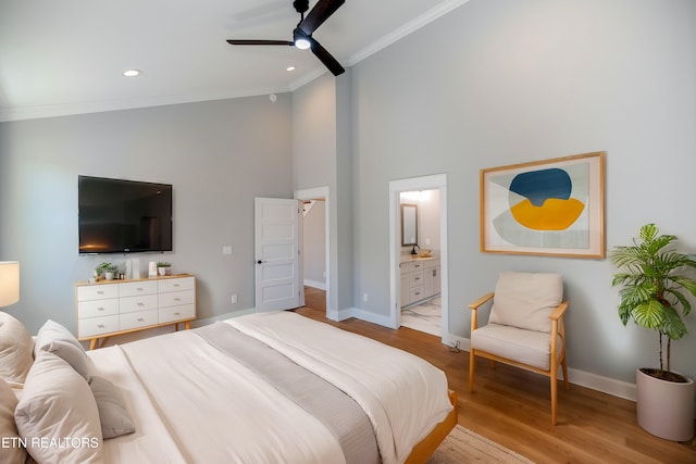 bedroom featuring wood finished floors, baseboards, ensuite bath, recessed lighting, and crown molding