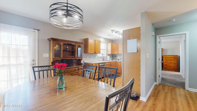 dining room featuring an inviting chandelier, light wood-style flooring, and baseboards