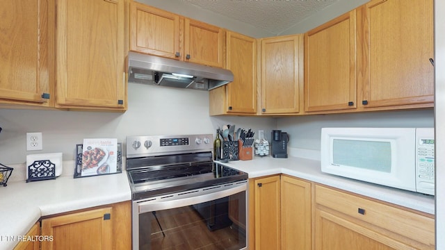 kitchen with under cabinet range hood, stainless steel electric stove, white microwave, and light countertops