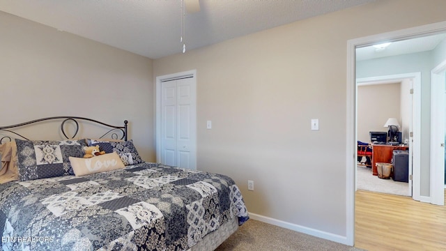 bedroom with baseboards, carpet flooring, wood finished floors, a closet, and a textured ceiling