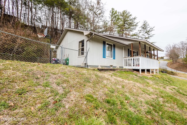 exterior space featuring a porch, a yard, and fence