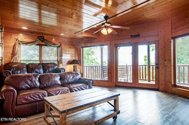 living room with wooden walls, wood ceiling, and a wealth of natural light