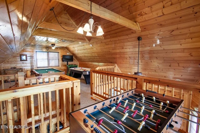 playroom with wooden walls, vaulted ceiling with beams, wooden ceiling, carpet flooring, and ceiling fan with notable chandelier