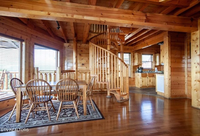 dining room featuring wood walls, stairs, and dark wood-style flooring