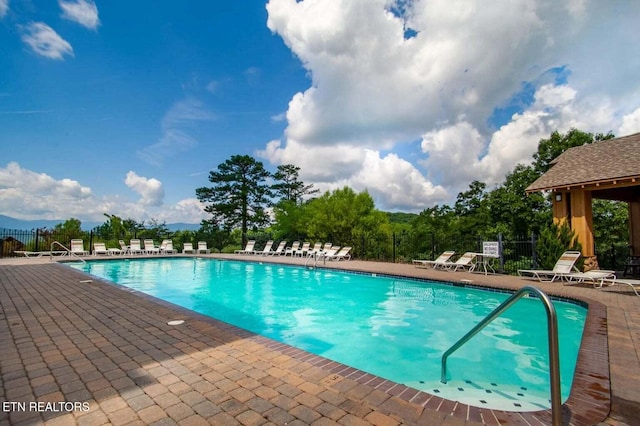 pool with a patio and fence