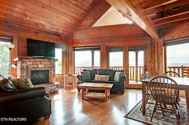 living room featuring wood finished floors, plenty of natural light, wood ceiling, and wood walls