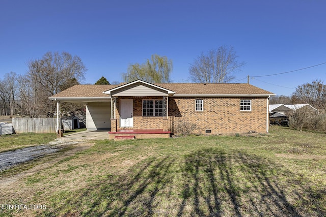 single story home featuring brick siding, fence, a front yard, a carport, and driveway