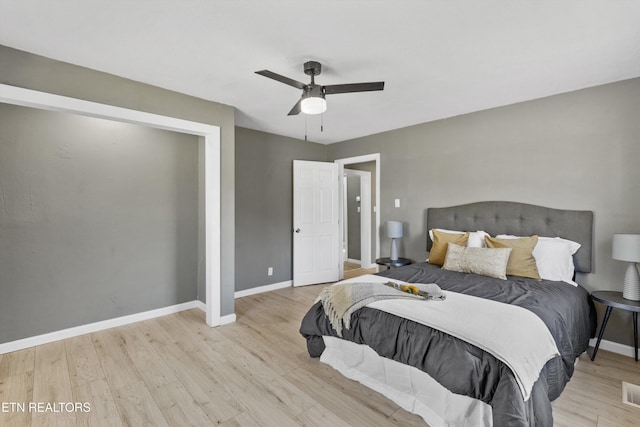 bedroom with light wood-type flooring, baseboards, visible vents, and ceiling fan