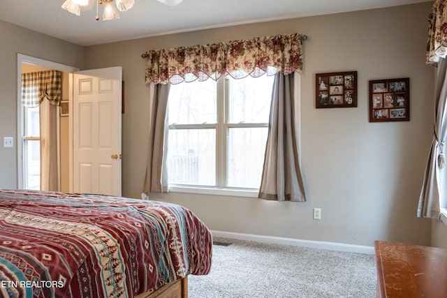 bedroom with baseboards, multiple windows, and carpet