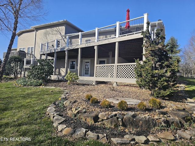 rear view of property featuring a lawn and a wooden deck