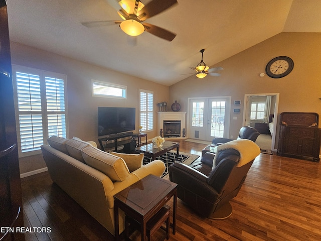 living room with ceiling fan, plenty of natural light, wood finished floors, and vaulted ceiling