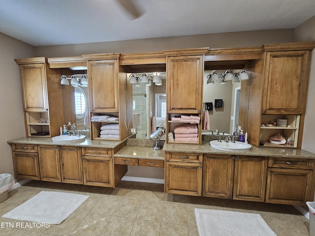 bathroom featuring tile patterned floors, baseboards, and vanity