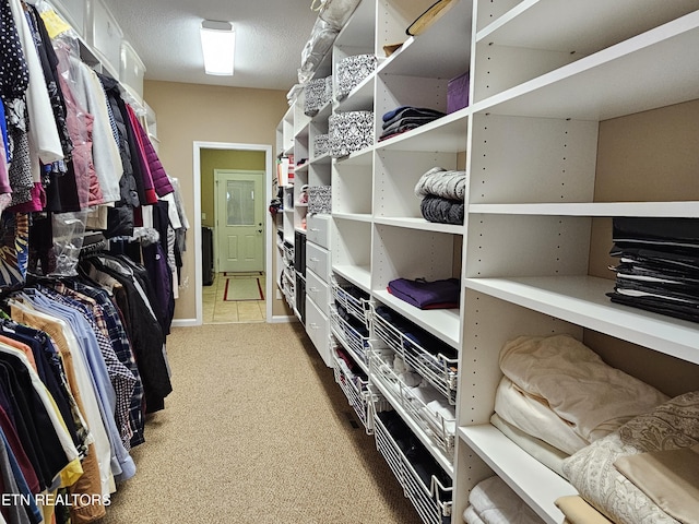 walk in closet featuring light colored carpet