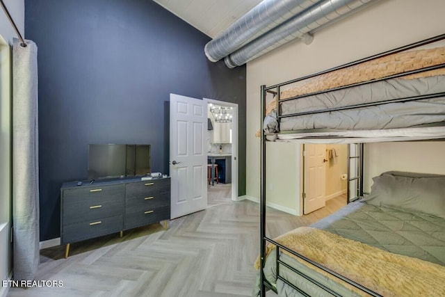 bedroom featuring baseboards and a towering ceiling