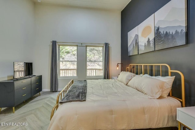 bedroom featuring baseboards and a towering ceiling