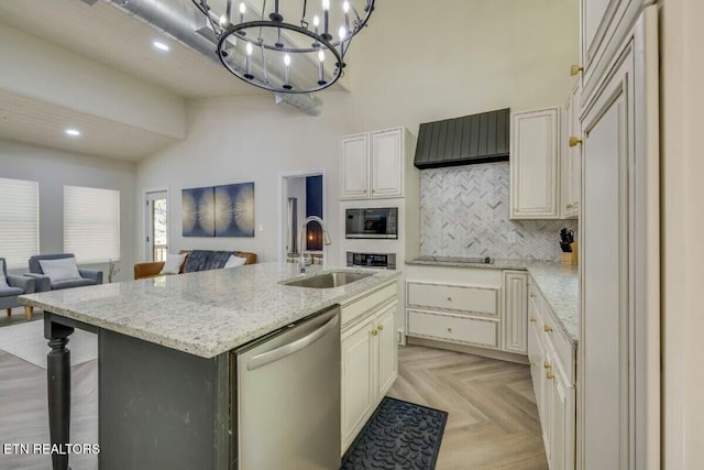 kitchen with a sink, stainless steel dishwasher, a high ceiling, and open floor plan