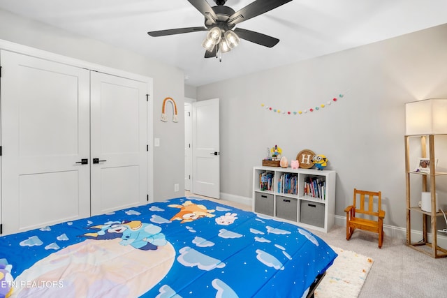 carpeted bedroom featuring baseboards, a closet, and ceiling fan