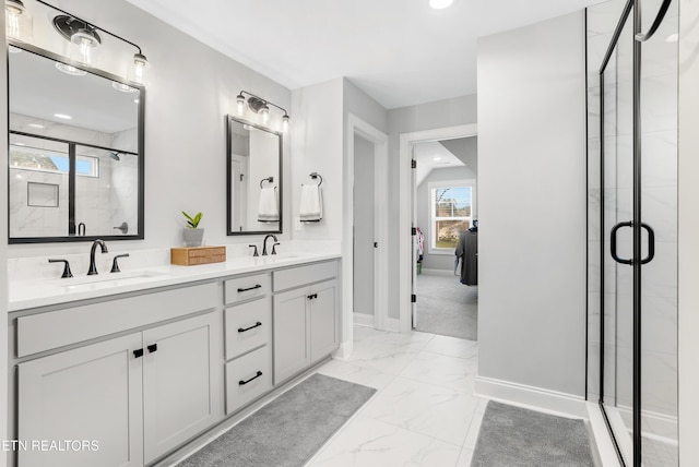 ensuite bathroom with marble finish floor, a stall shower, ensuite bathroom, a sink, and baseboards