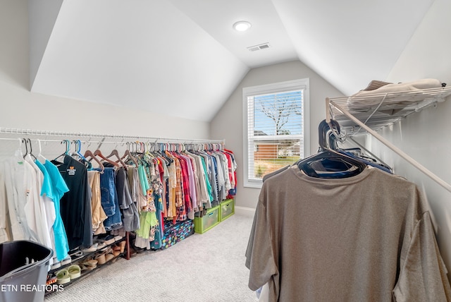 spacious closet featuring carpet flooring, visible vents, and vaulted ceiling