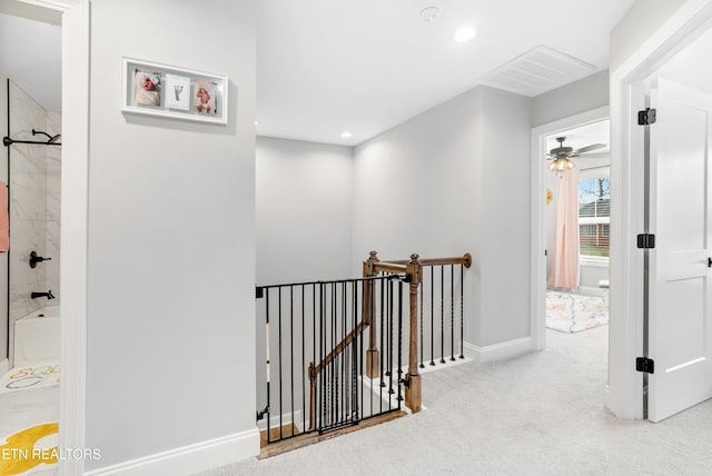 hallway featuring visible vents, baseboards, carpet, an upstairs landing, and recessed lighting