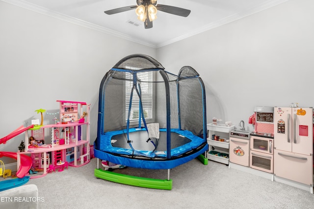 playroom with visible vents, ceiling fan, carpet, and ornamental molding