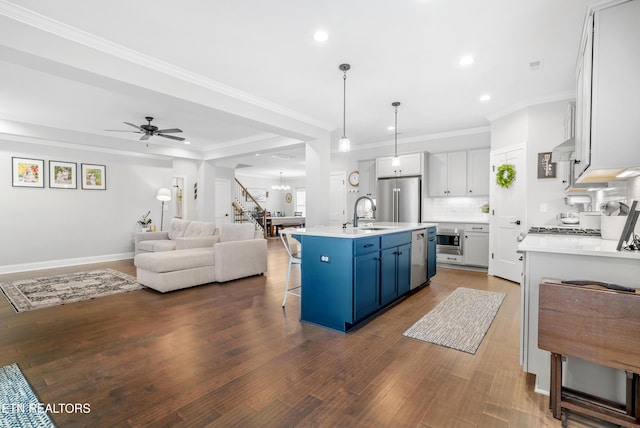 kitchen with dark wood-style floors, blue cabinetry, open floor plan, appliances with stainless steel finishes, and tasteful backsplash