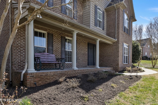 view of home's exterior featuring brick siding and a porch