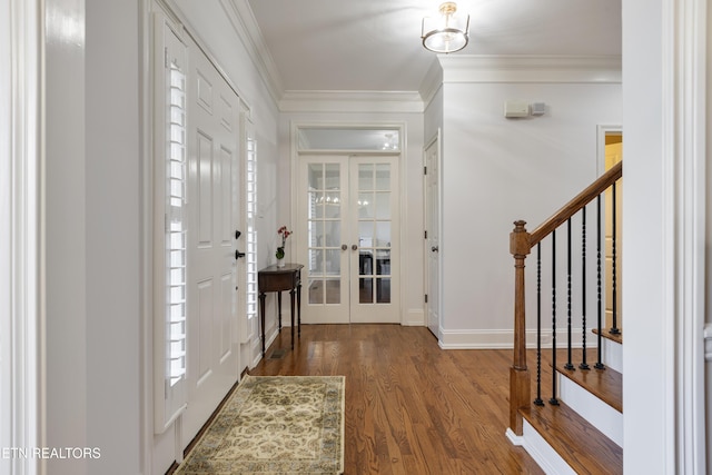 foyer with wood finished floors, baseboards, stairs, french doors, and crown molding