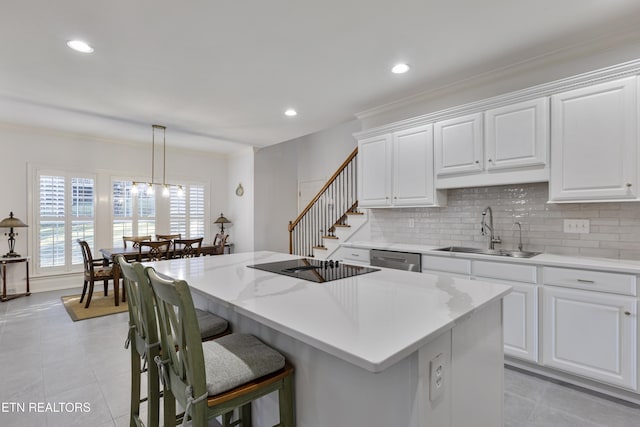 kitchen with tasteful backsplash, a center island, dishwasher, a kitchen breakfast bar, and a sink