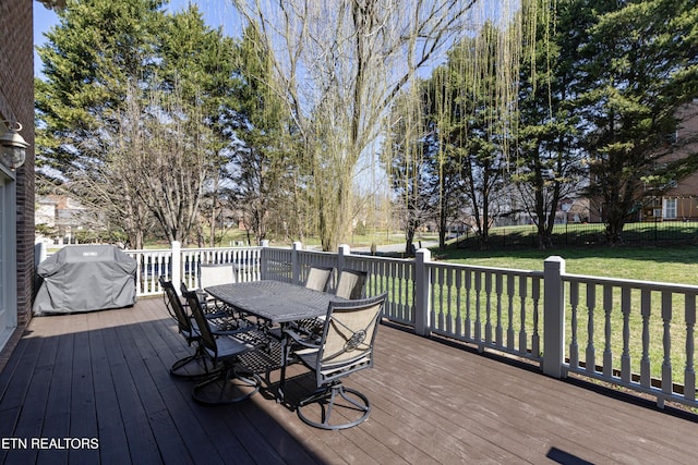 deck with outdoor dining space, area for grilling, a yard, and fence