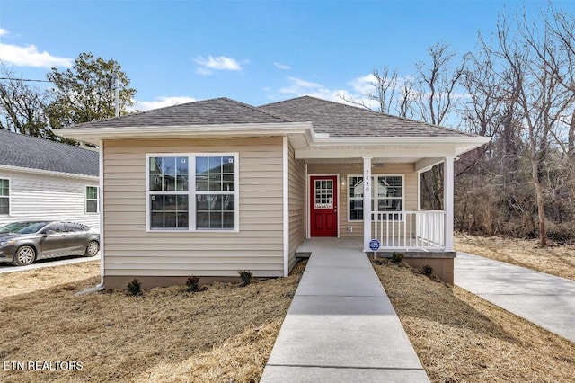 bungalow-style home with a porch and roof with shingles