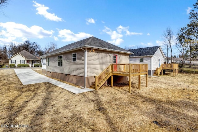 view of side of property with driveway, stairs, and a deck