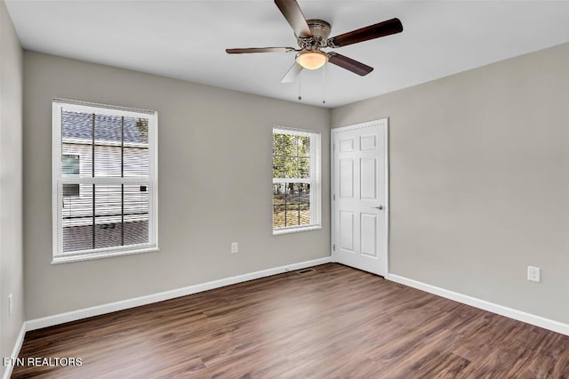 unfurnished room with a ceiling fan, baseboards, and wood finished floors