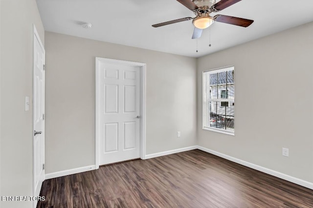 unfurnished bedroom featuring dark wood finished floors, a ceiling fan, and baseboards