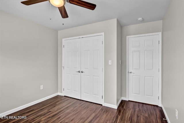 unfurnished bedroom featuring a closet, baseboards, and dark wood-type flooring