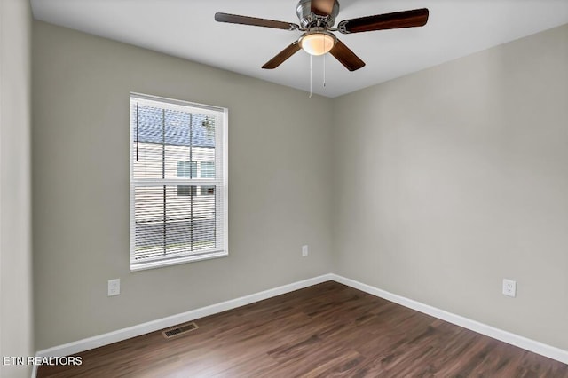 unfurnished room with visible vents, baseboards, a ceiling fan, and dark wood-style flooring