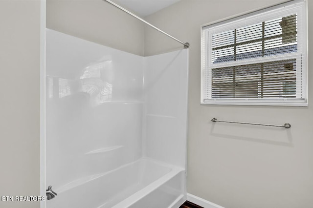 full bath featuring baseboards and bathing tub / shower combination