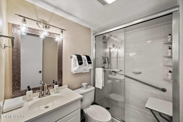 full bathroom featuring visible vents, toilet, a stall shower, and vanity