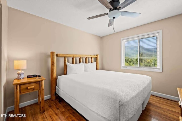 bedroom with a ceiling fan, baseboards, and wood finished floors