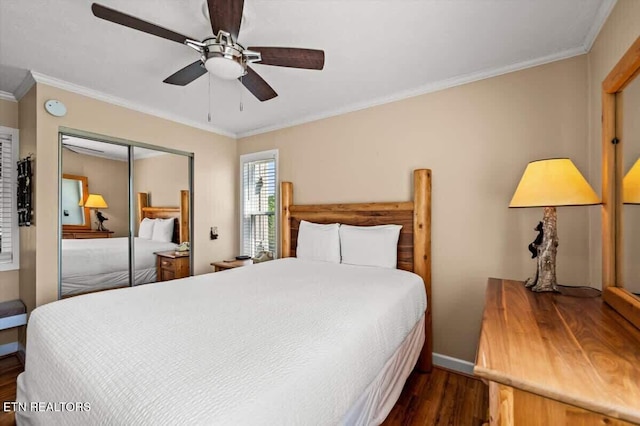 bedroom featuring a ceiling fan, wood finished floors, baseboards, a closet, and crown molding