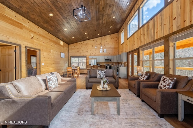 living area with high vaulted ceiling, recessed lighting, wood walls, wooden ceiling, and light wood-type flooring