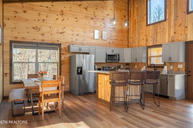 kitchen with appliances with stainless steel finishes, wood walls, and light countertops