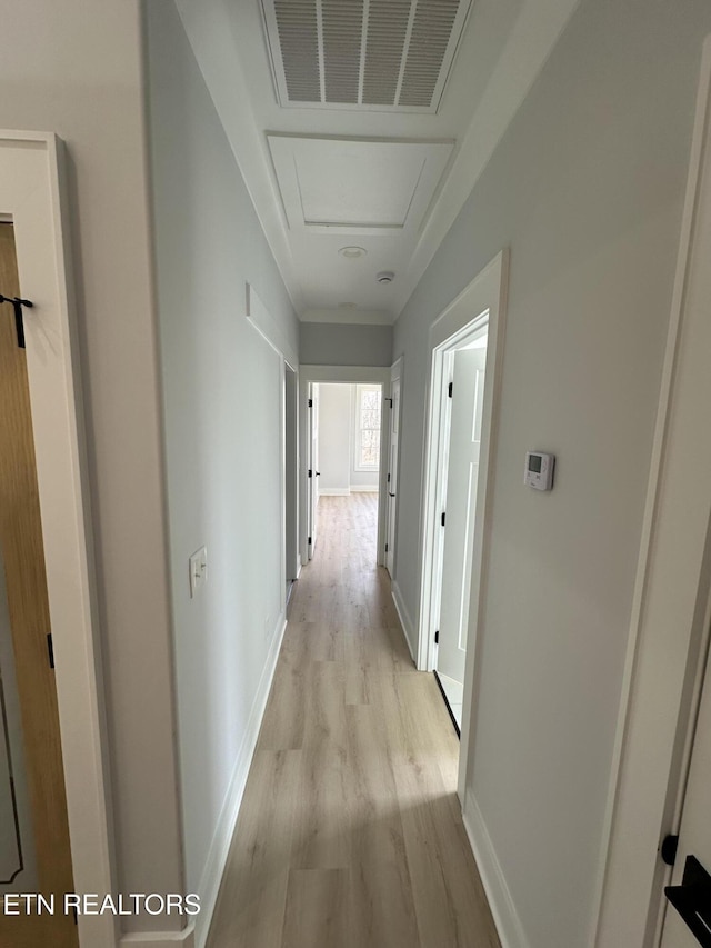 corridor with visible vents, baseboards, and light wood-style floors