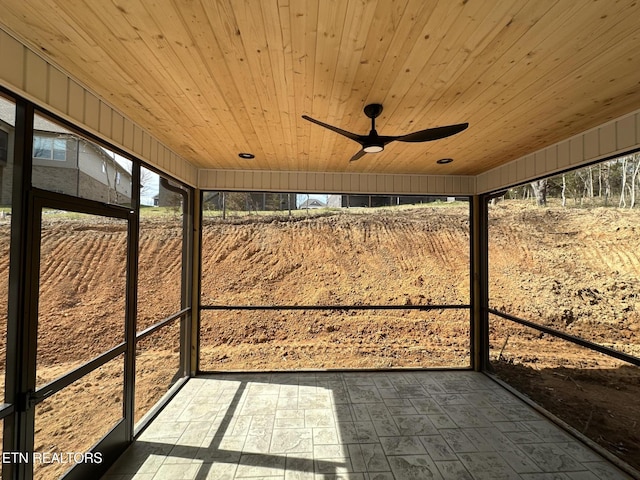 unfurnished sunroom with ceiling fan and wooden ceiling