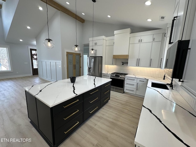 kitchen featuring visible vents, a sink, appliances with stainless steel finishes, custom exhaust hood, and dark cabinets